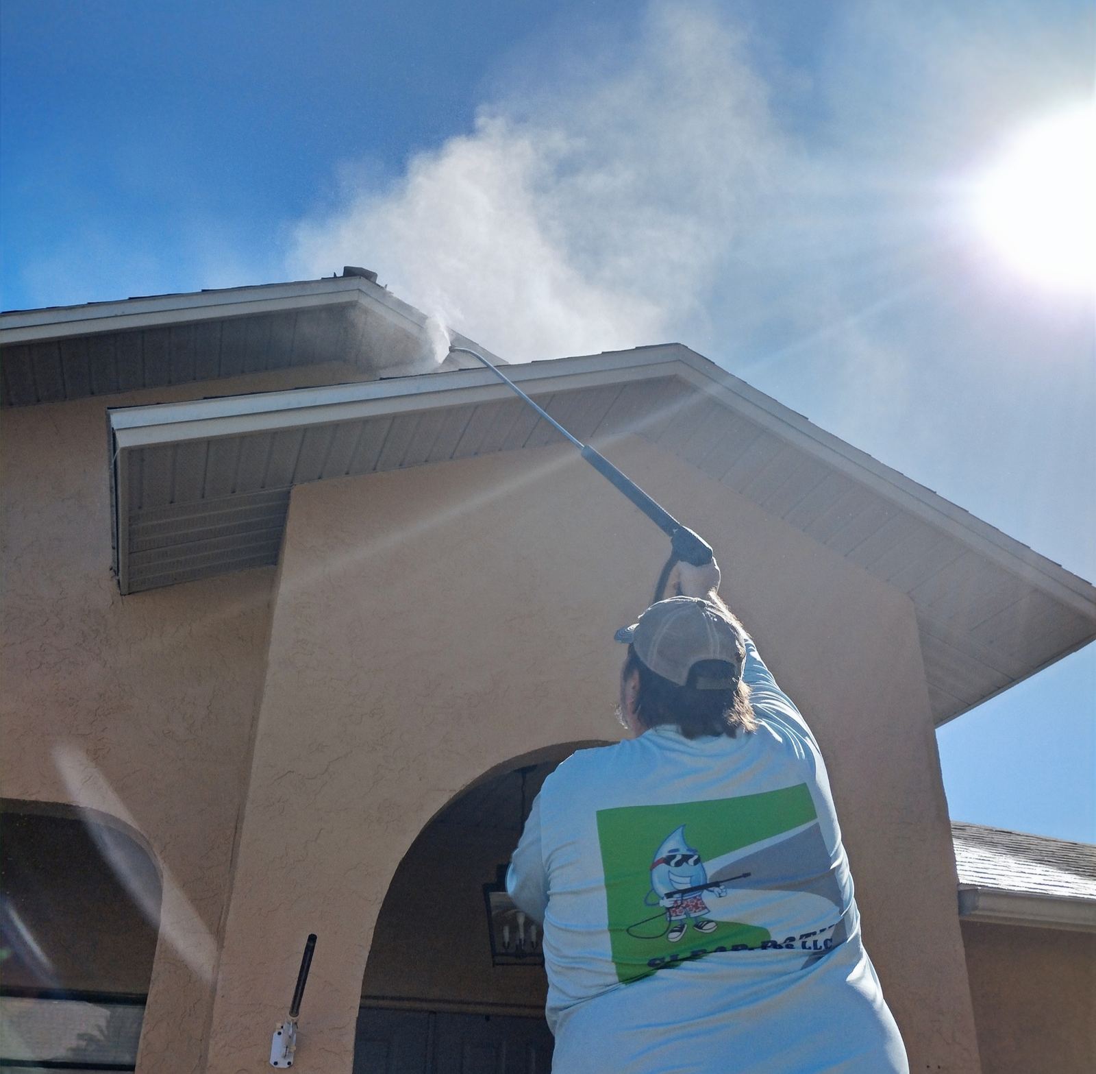 Clear Path Pressure Pros technician soft washing a home's roofline